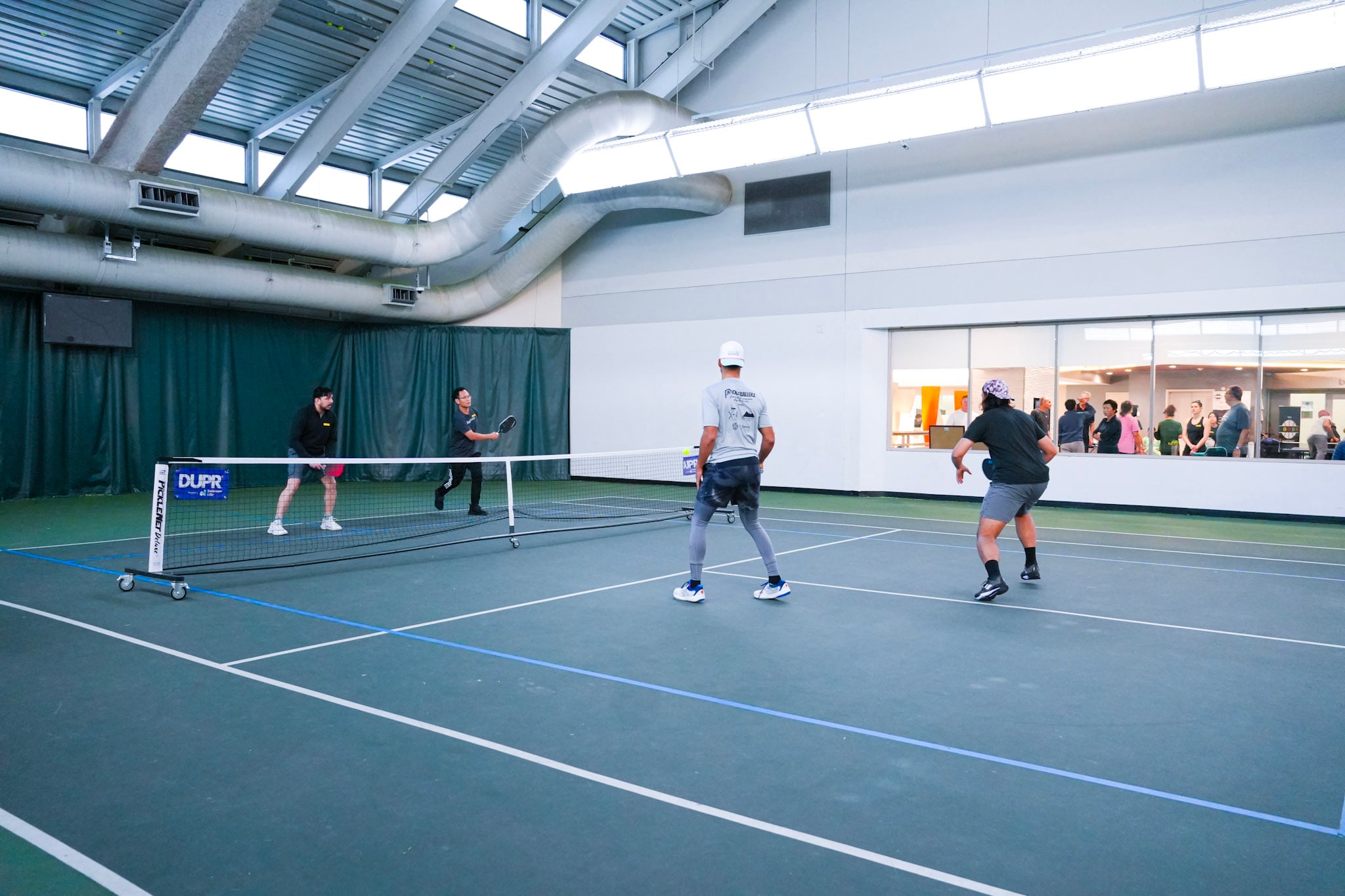 CourtQuest tournament action — a doubles rally mid-point